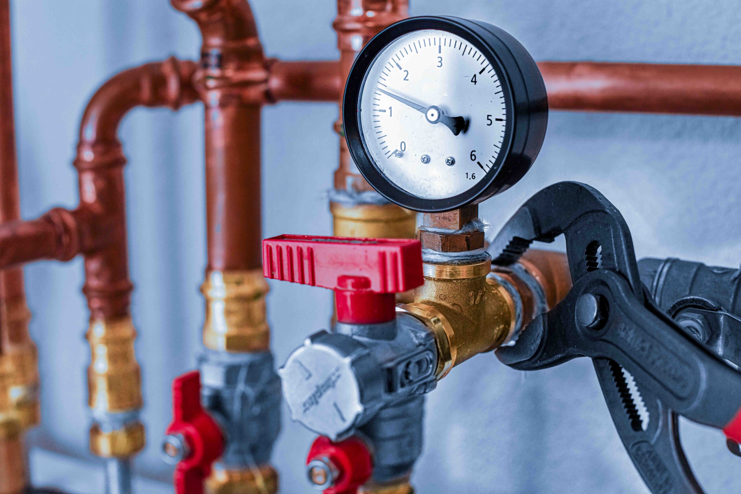 Plumbing concept or service water worker. copper pipeline of a heating system in technical room. Boiler and expansion expansion tank system, detail of pressure gauge.